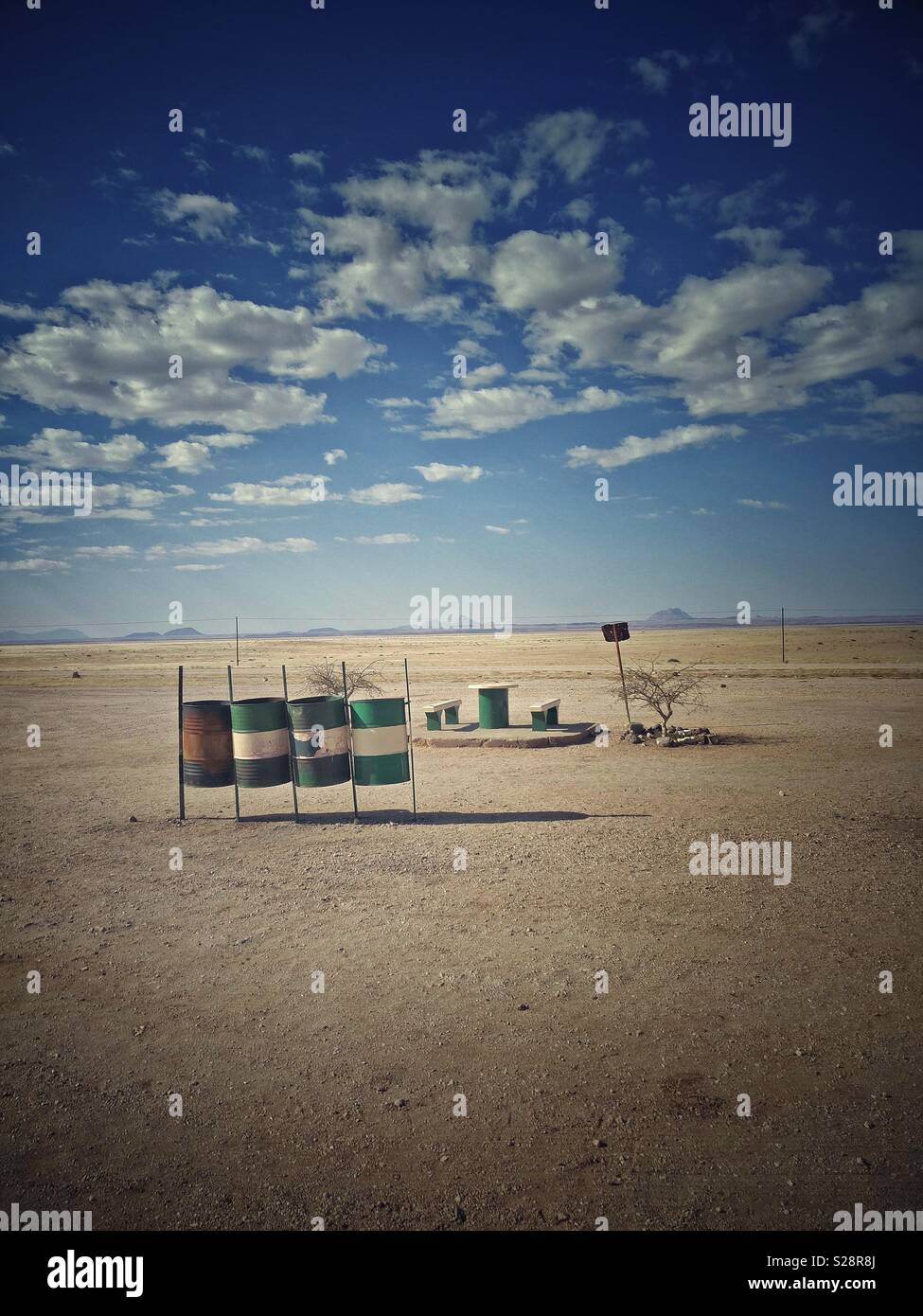 Roadside picnic area with oil drums for recycling bins, Namibia. Vintage look. Vertical portrait format with copyspace. - Smartphone Captured Stock Image
