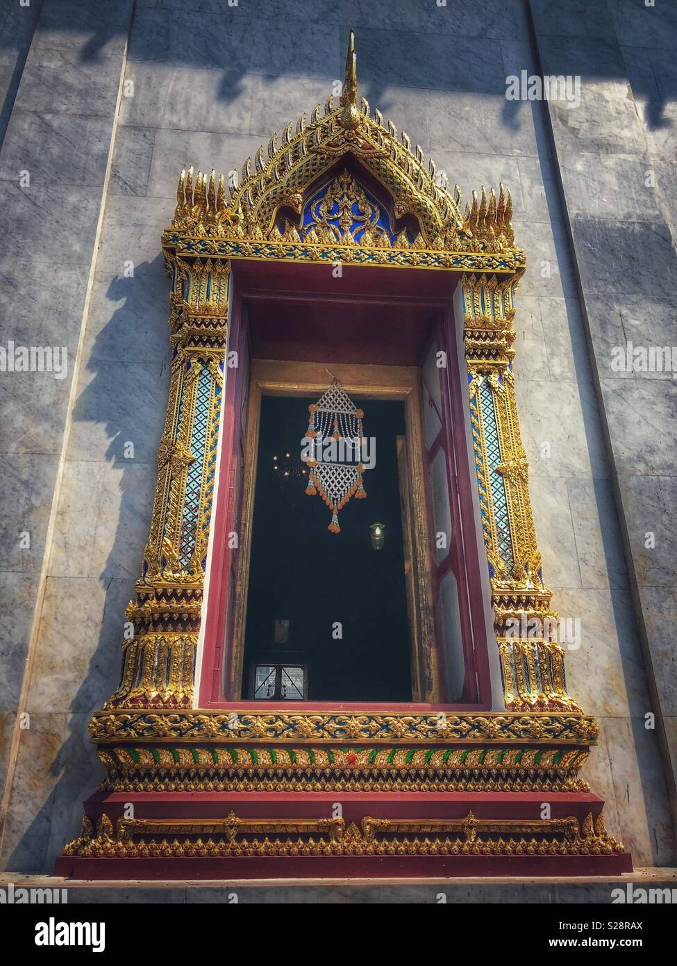 An ornate window of a Buddhist temple in Bangkok, Thailand. - Smartphone Captured Stock Image