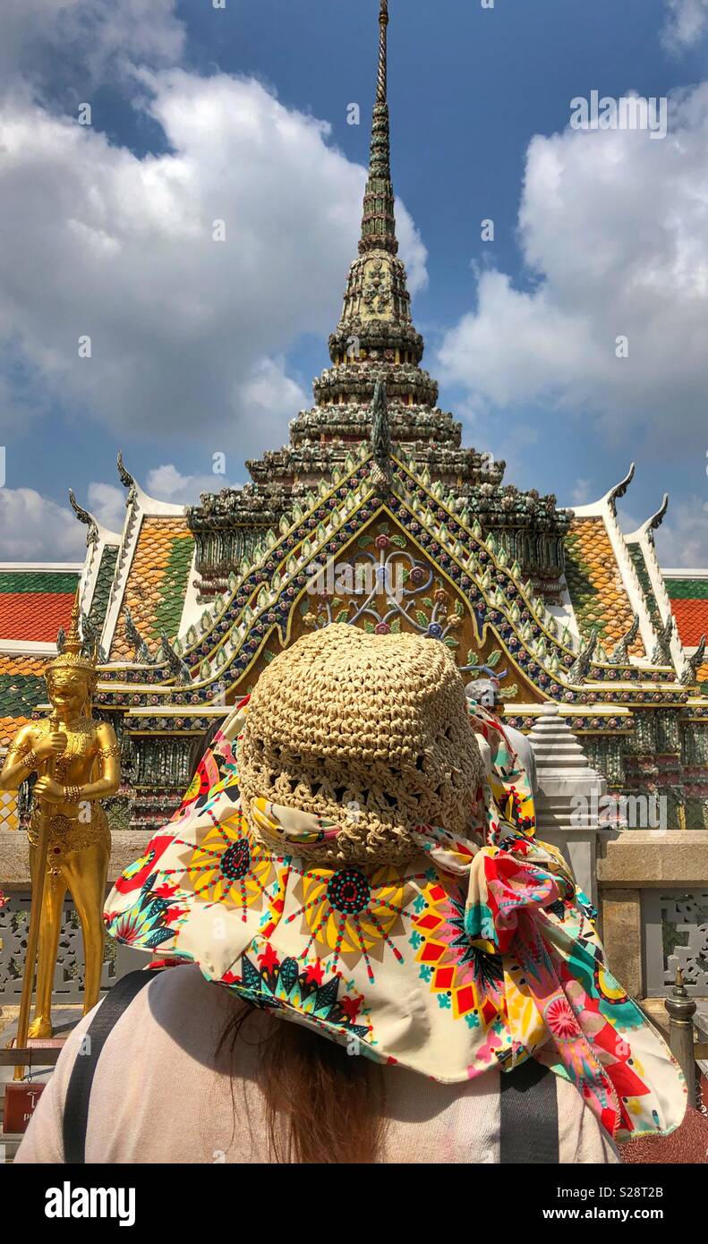 A female tourist standing in front of a Buddhist temple in Bangkok, Thailand. - Smartphone Captured Stock Image
