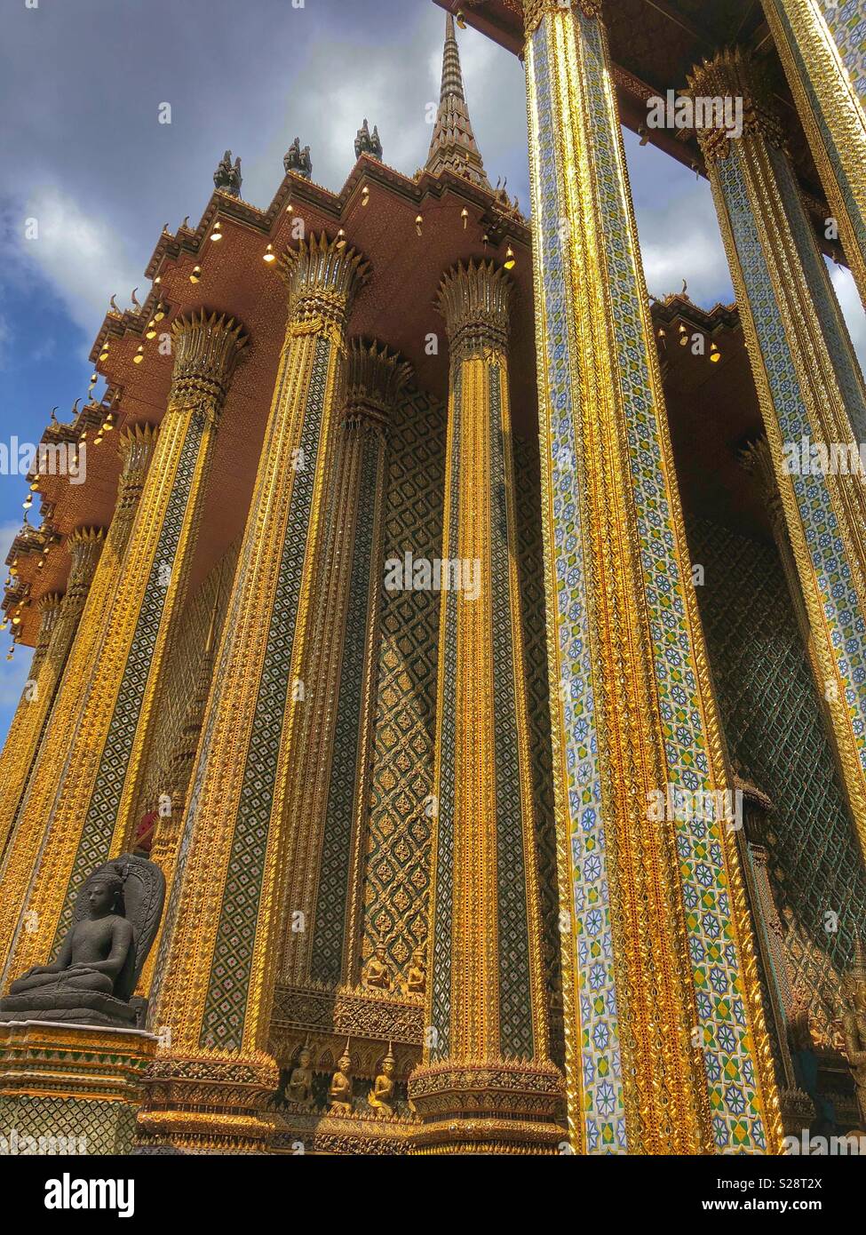 Ornate golden columns at a Buddhist temple in Bangkok, Thailand. - Smartphone Captured Stock Image