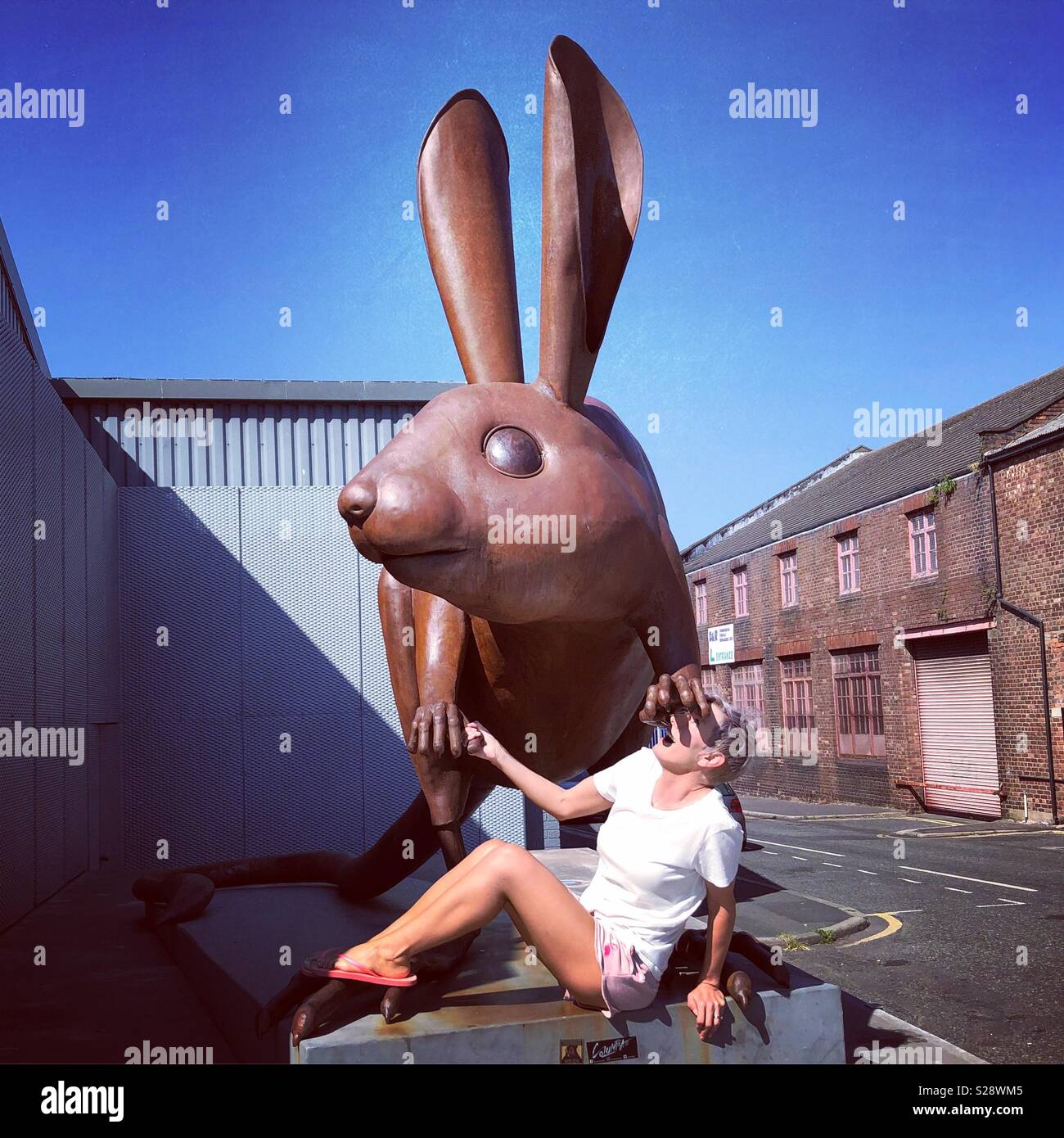 Woman underneath sculpture of rabbit - Smartphone Captured Stock Image