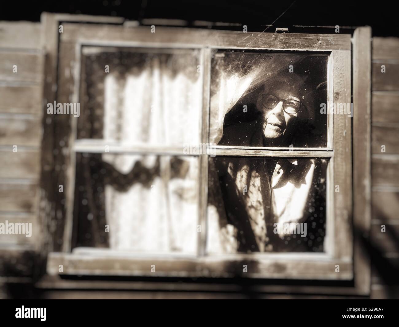 Elderly woman living alone and suffering from macular degeneration in her eyes making it difficult to leave the house on her own. - Smartphone Captured Stock Image