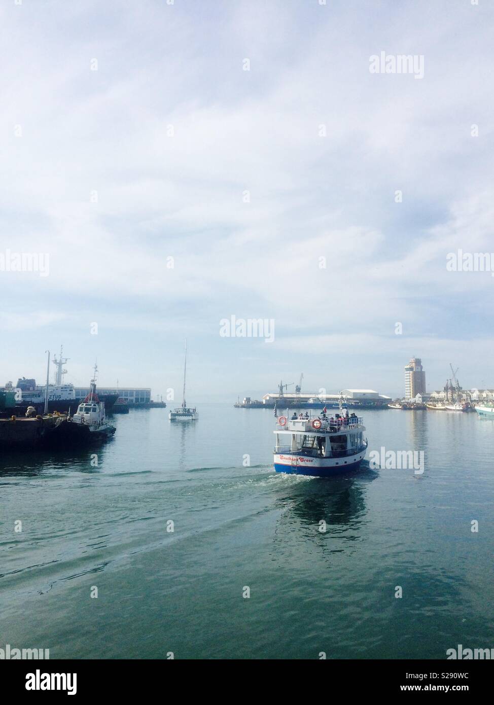 Boats going out to sea on a calm day in the working harbour of Cape Town city port in South Africa - Smartphone Captured Stock Image