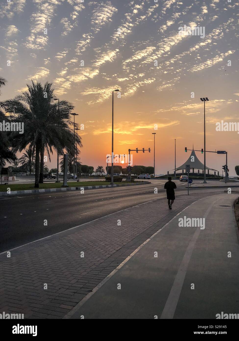 A man jogging near corniche park abu dhabi, A peaceful evening and colorful sunset Stock Photo