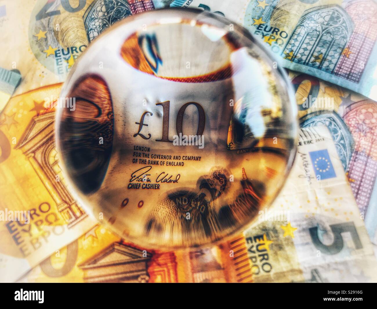 £10 note in a crystal ball, surrounded by euros. Brexit concept - Smartphone Captured Stock Image