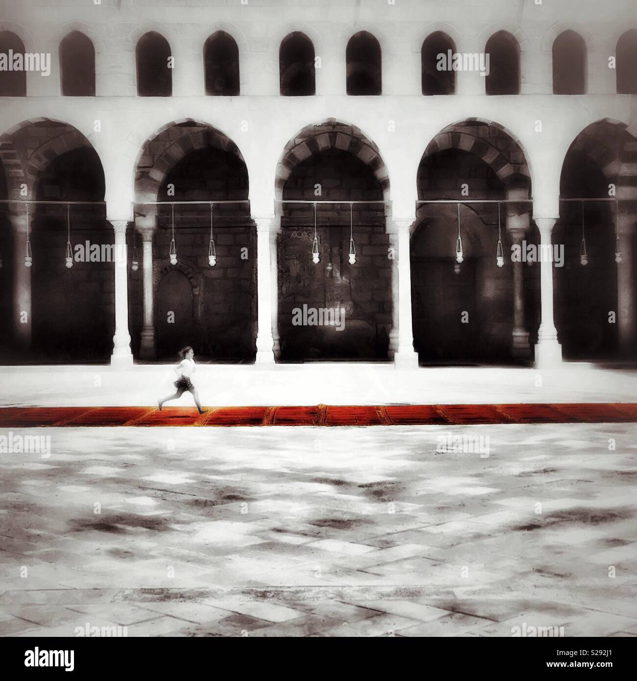 Girl runs through mosque Stock Photo