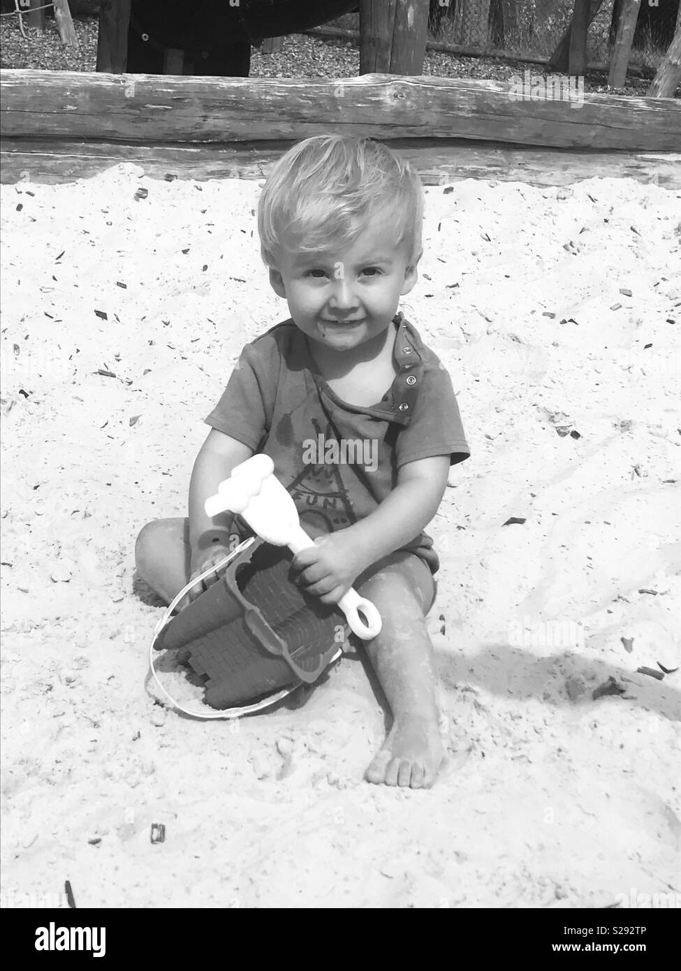 Little boy in sand pit with bucket & spade Stock Photo