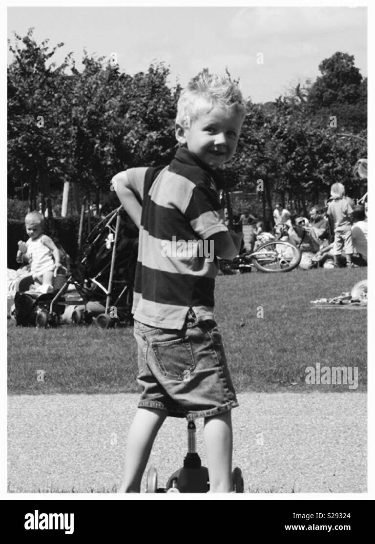 Little boy on scooter in park Stock Photo