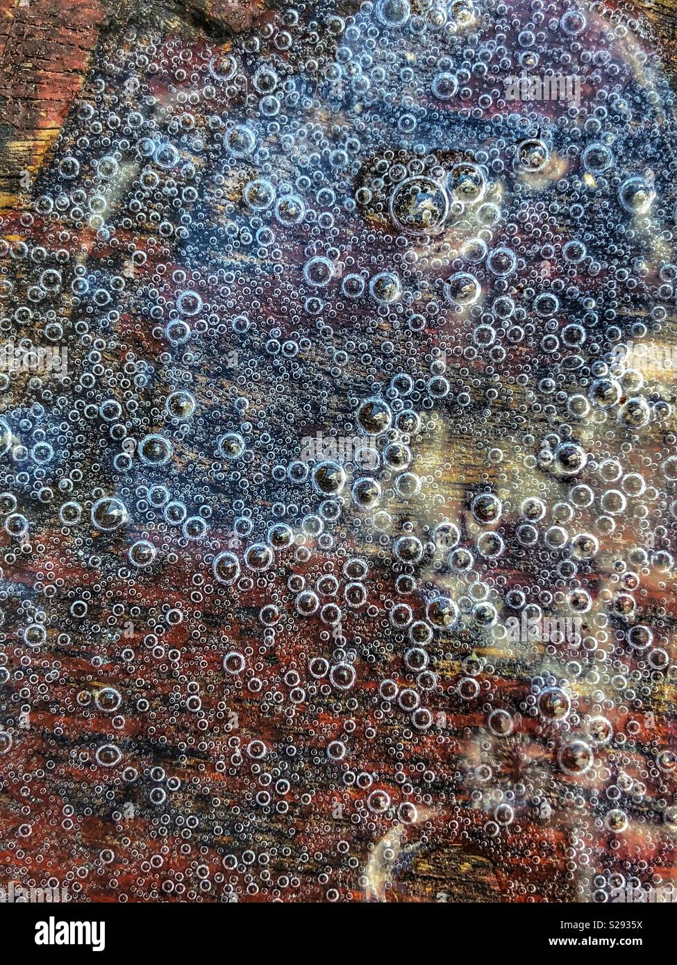 Bubbles of fizzy prosecco wine on a wooden table - Smartphone Captured Stock Image