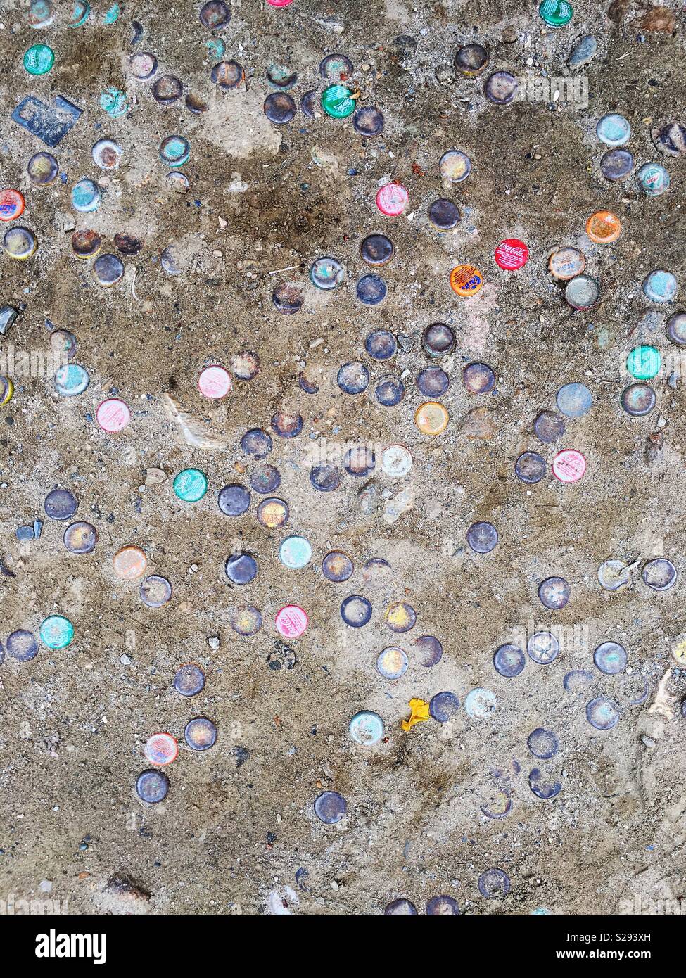Bottle caps embedded in the ground Stock Photo