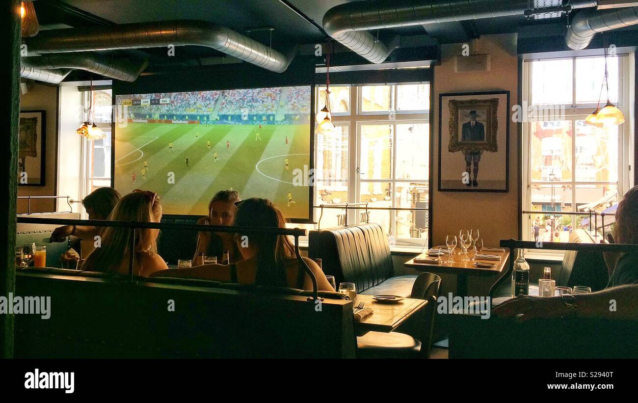 People watching World Cup football and eating lunch in a city restaurant bar in London, U.K. 2018 Stock Photo