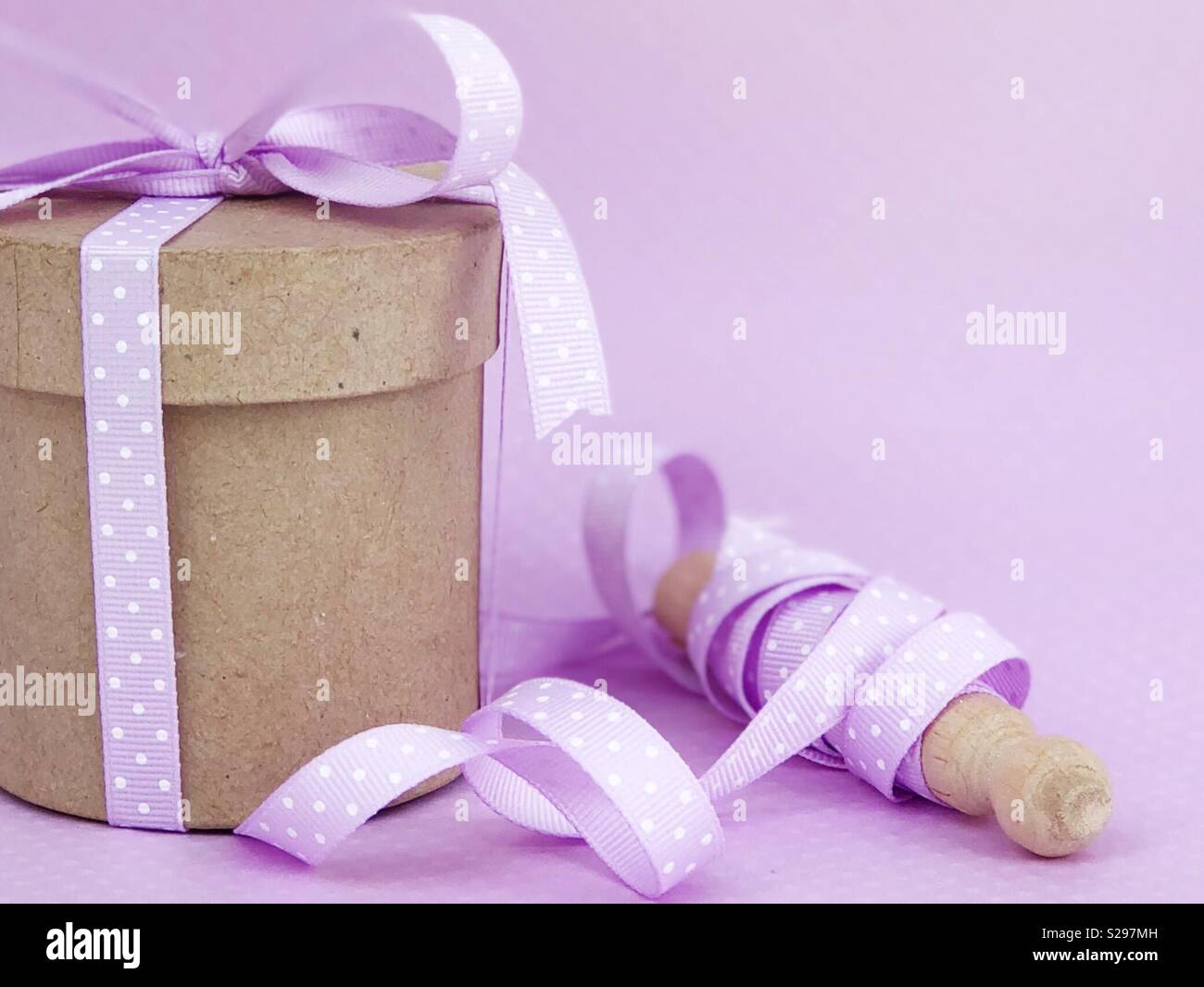 Kraft box and pastel purple ribbon. Purple back ground for color themed social media and/or online shop visual presence. Pretty image for small business owners with big dreams. Stock Photo