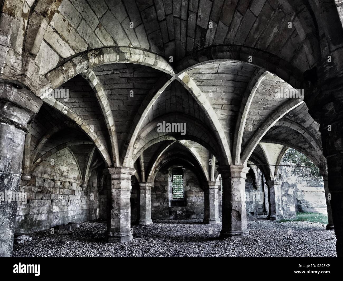 The interior of a gothic church with stone arches and pillars holding up an ornate ceiling Stock Photo