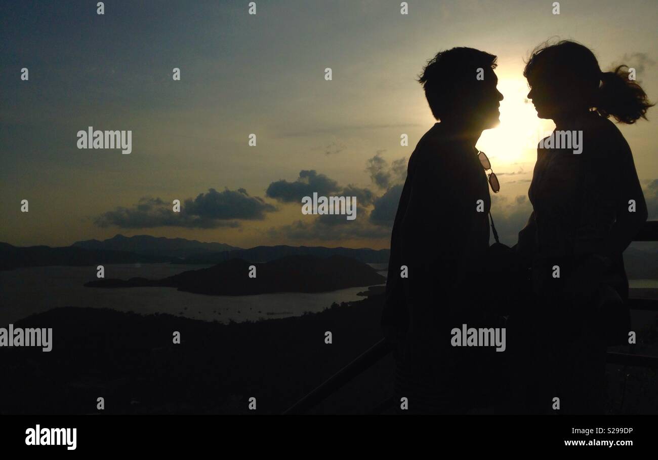 Silhoutte of a happy couple in a beautiful sunset Stock Photo