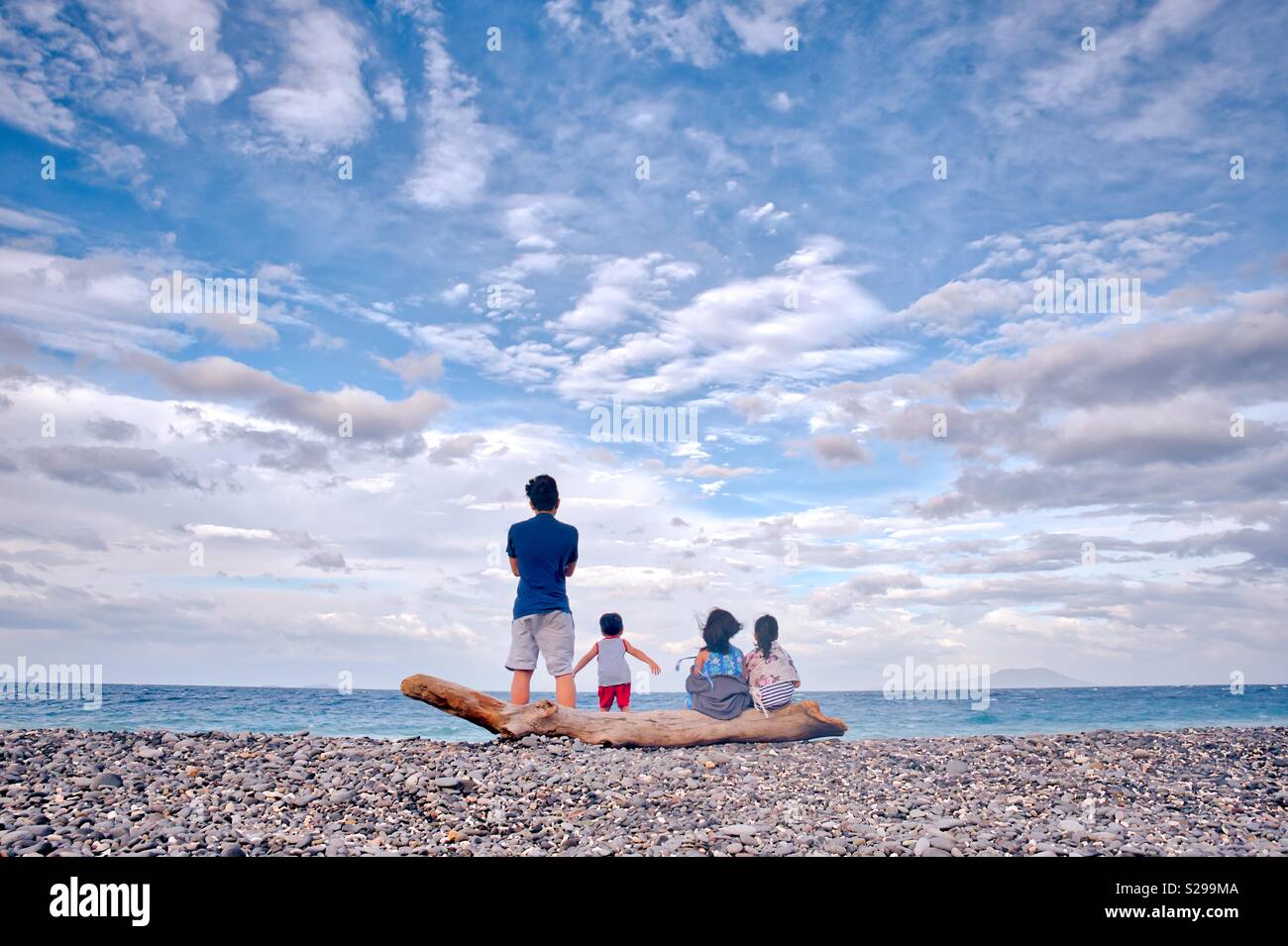 Siblings by the beach under the cloudy skies. Stock Photo