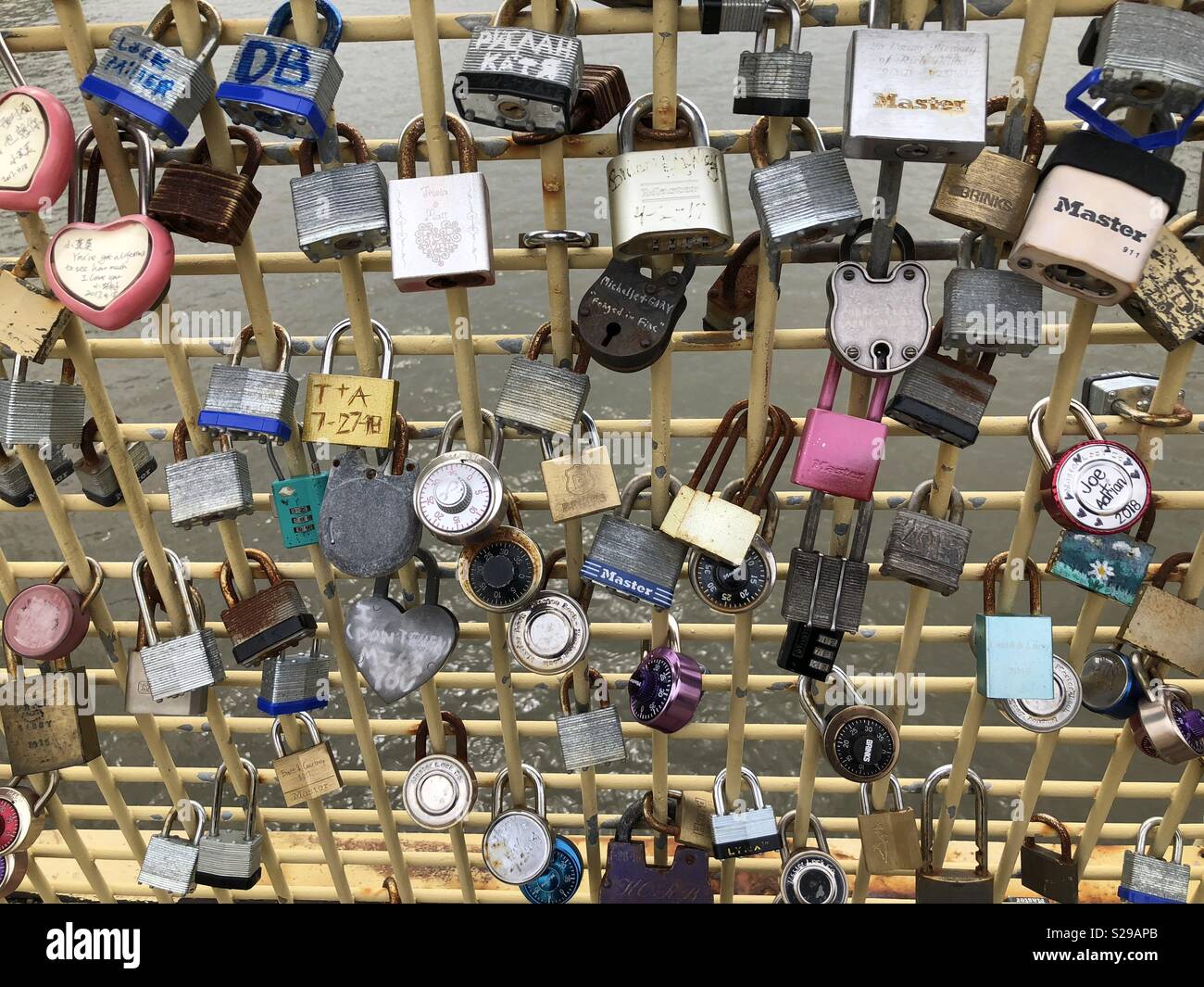 Many locks representing lovers, friends and family locked on a bridge railing Stock Photo