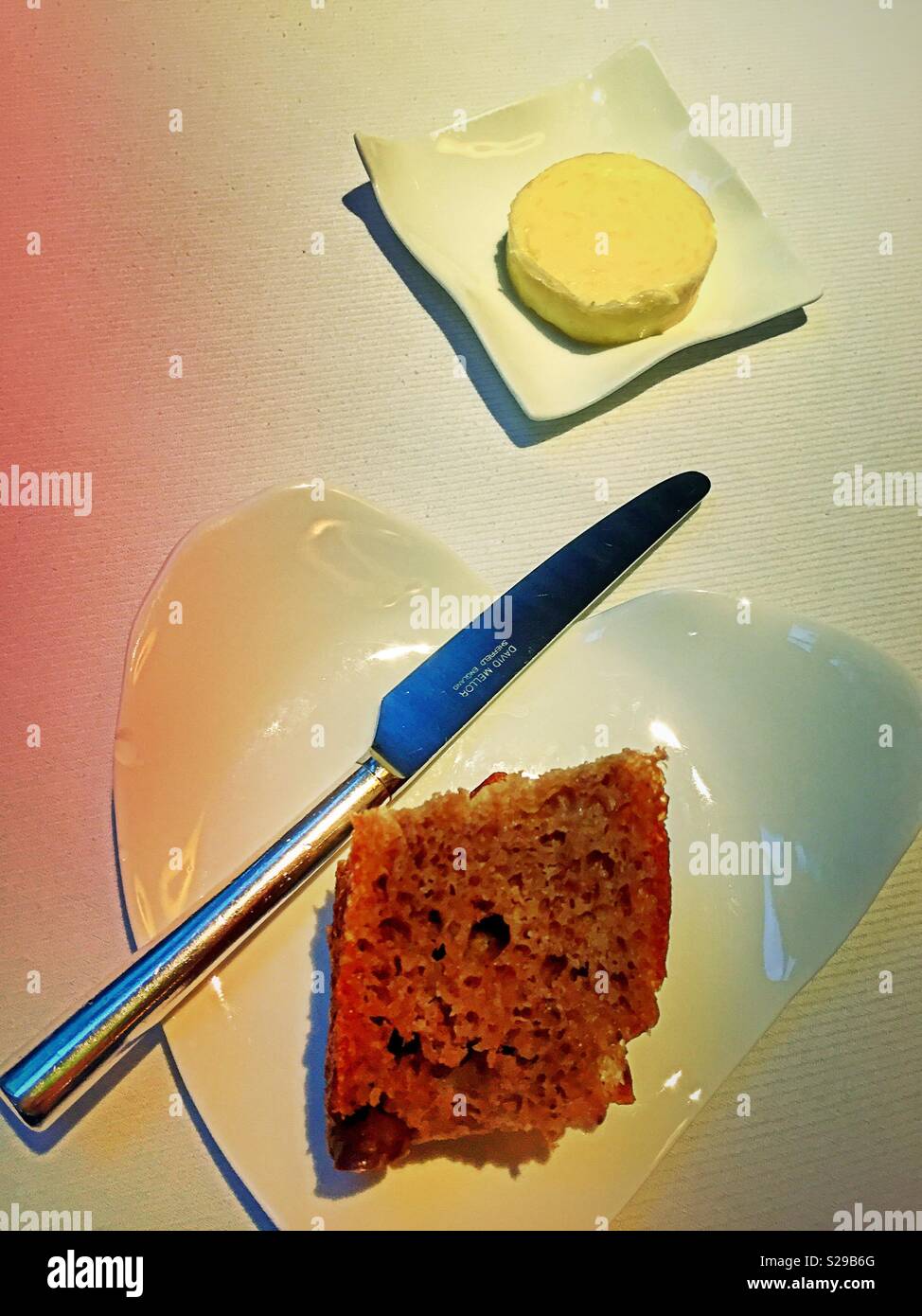 Bread and butter plates in a white tablecloth restaurant, USA - Smartphone Captured Stock Image