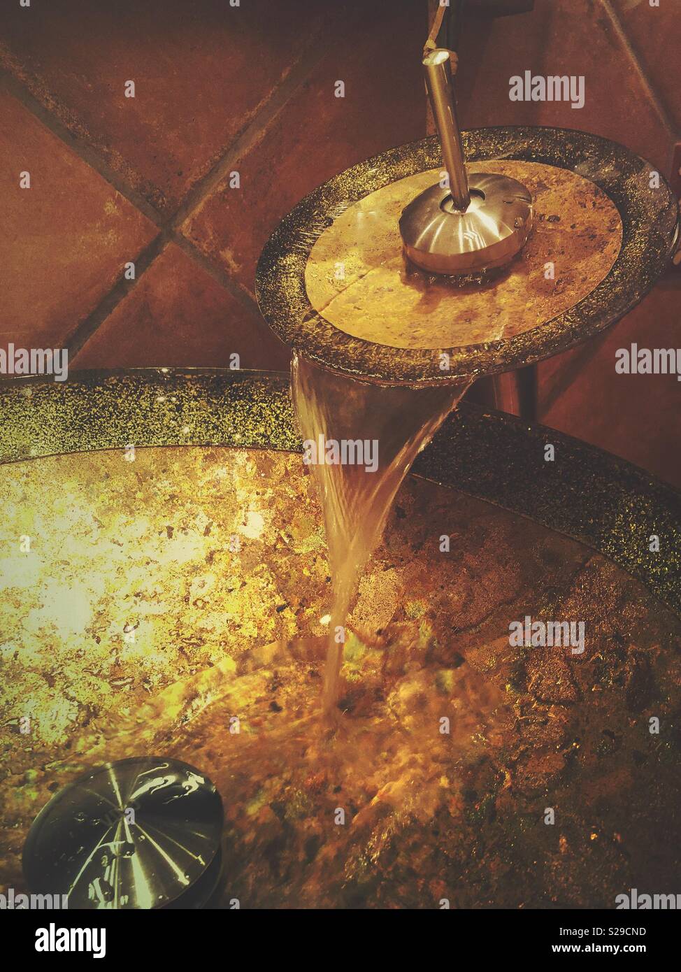 An unusual sink and faucet with water flowing. - Smartphone Captured Stock Image