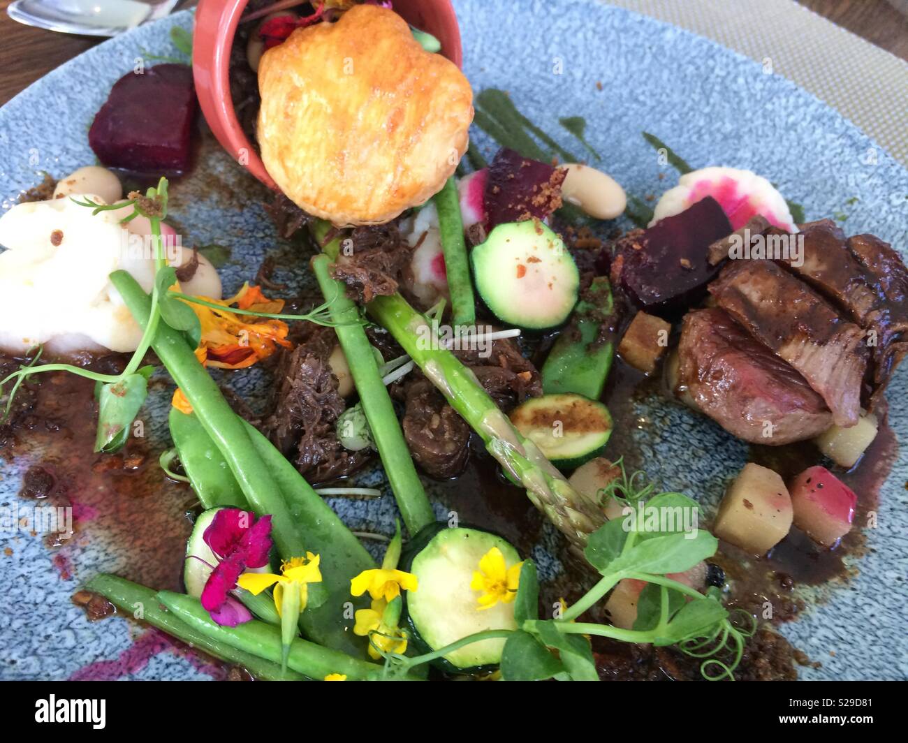 Beef pot pie and assorted vegetables as accompaniment served on blue serving plate as a healthy meal for lunch at an upmarket restaurant in Franschhoek, Cape Winelands - Smartphone Captured Stock Image