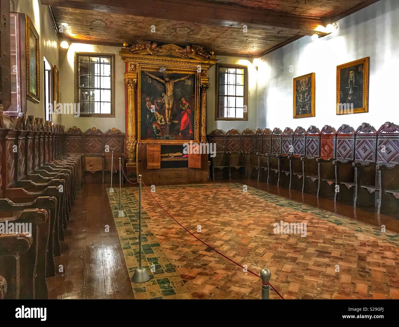 Santa Clara Convent, built for Franciscan Sisters in the 16th Century and still in use today, Funchal, Madeira, Portugal, Hand painted wooden angels and choir stalls line the walls of a chapel Stock Photo