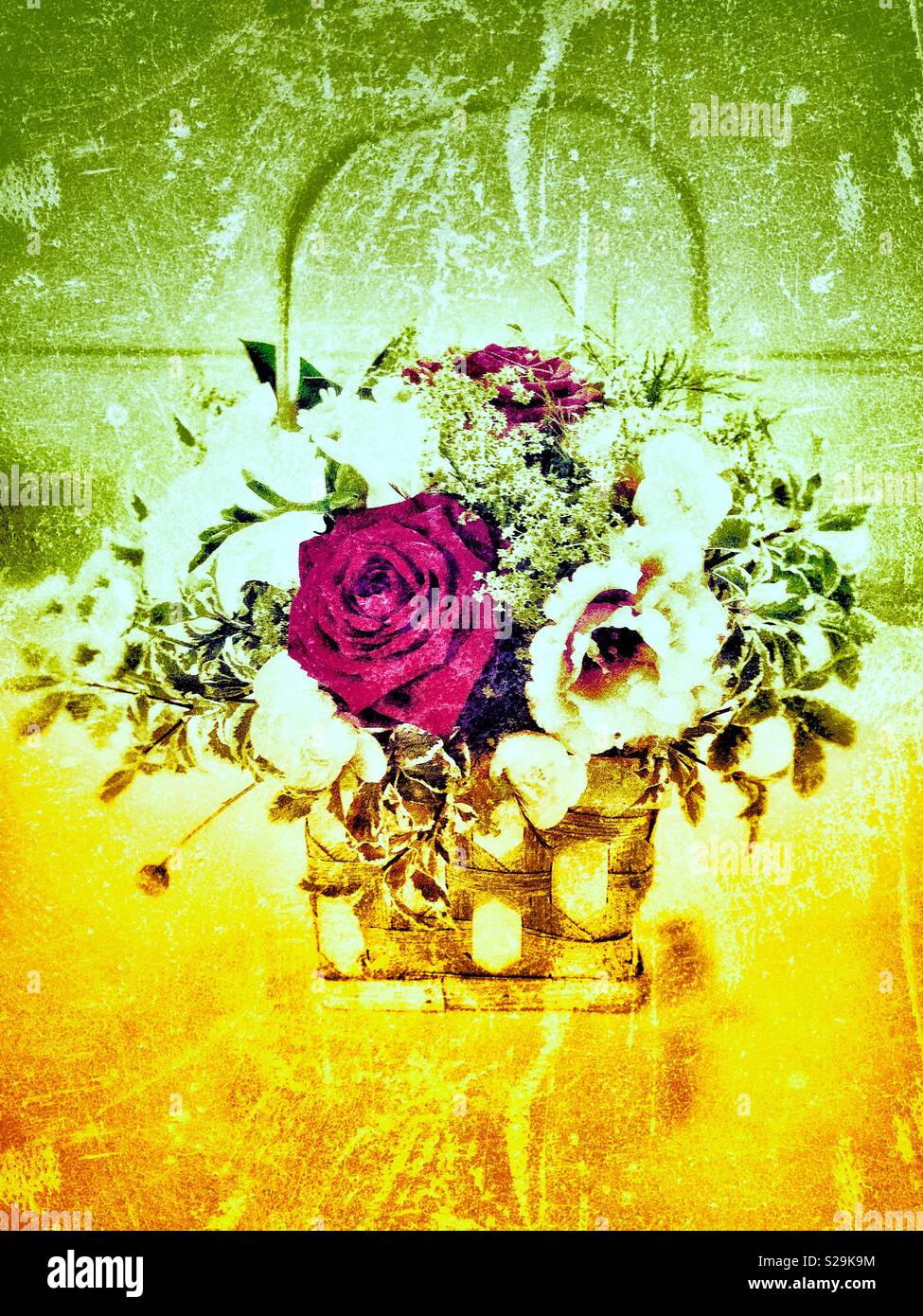 Basket of flowers, the image has been enhanced with a grunge effect’ using yellow and green shades Stock Photo
