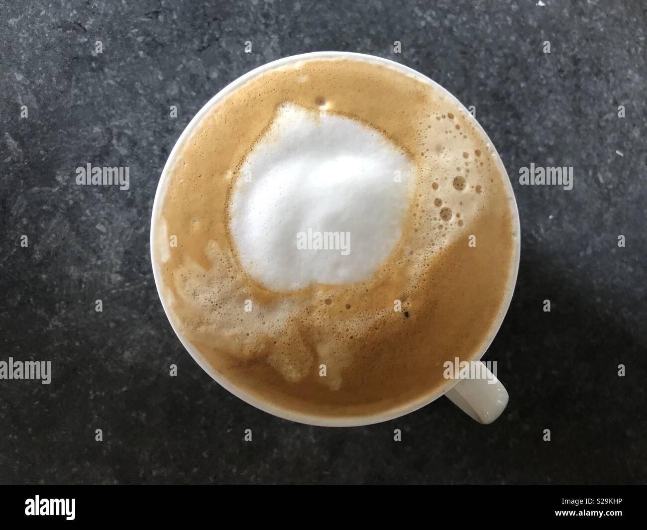Top down view of cappuccino coffee in a white cup- with no chocolate sprinkles - Smartphone Captured Stock Image