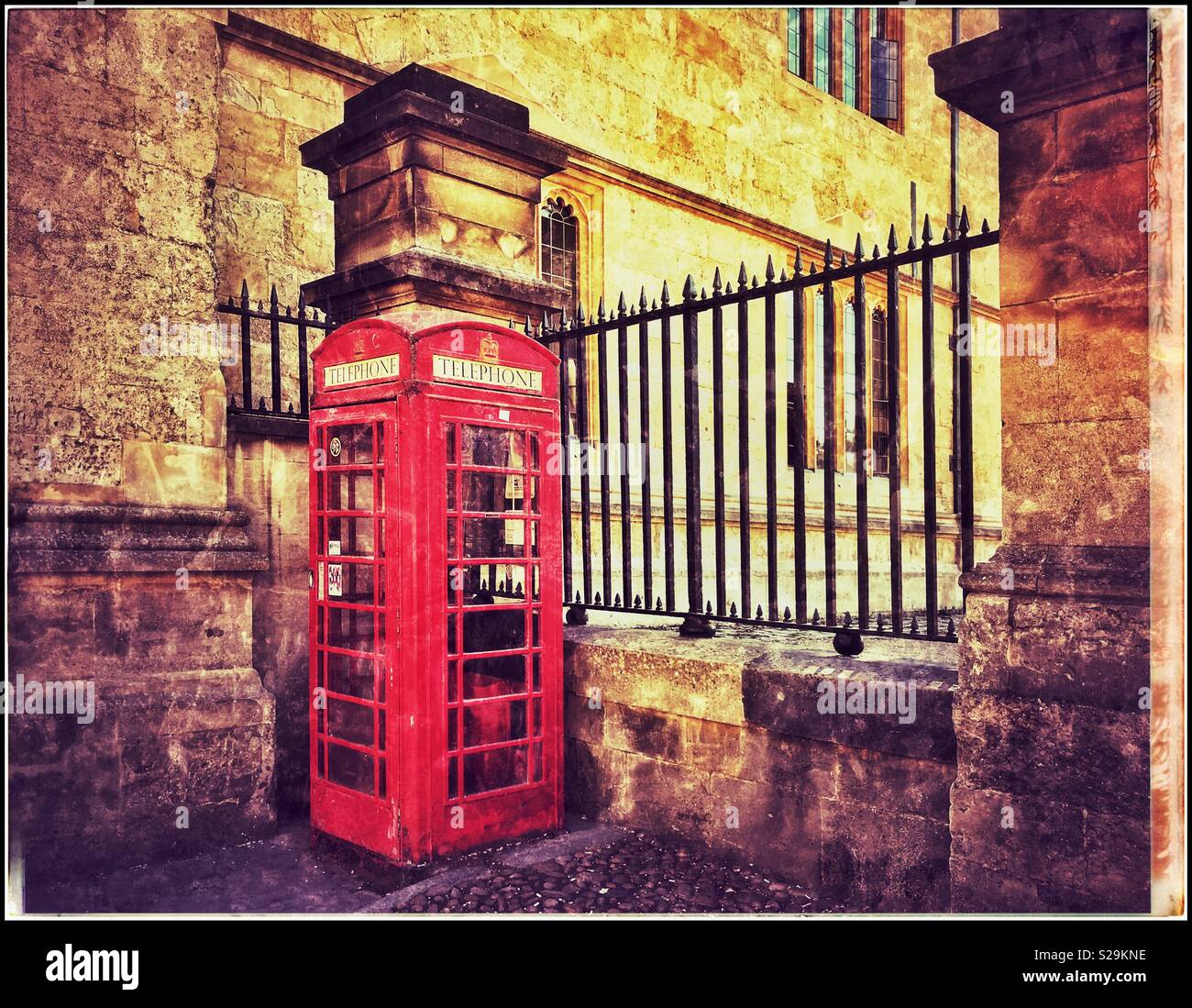 An iconic Red British public Telephone box or booth. The advent of cellphones has hastened their demise. A grunge picture with creative atmosphere. Photo Credit - © COLIN HOSKINS. - Smartphone Captured Stock Image