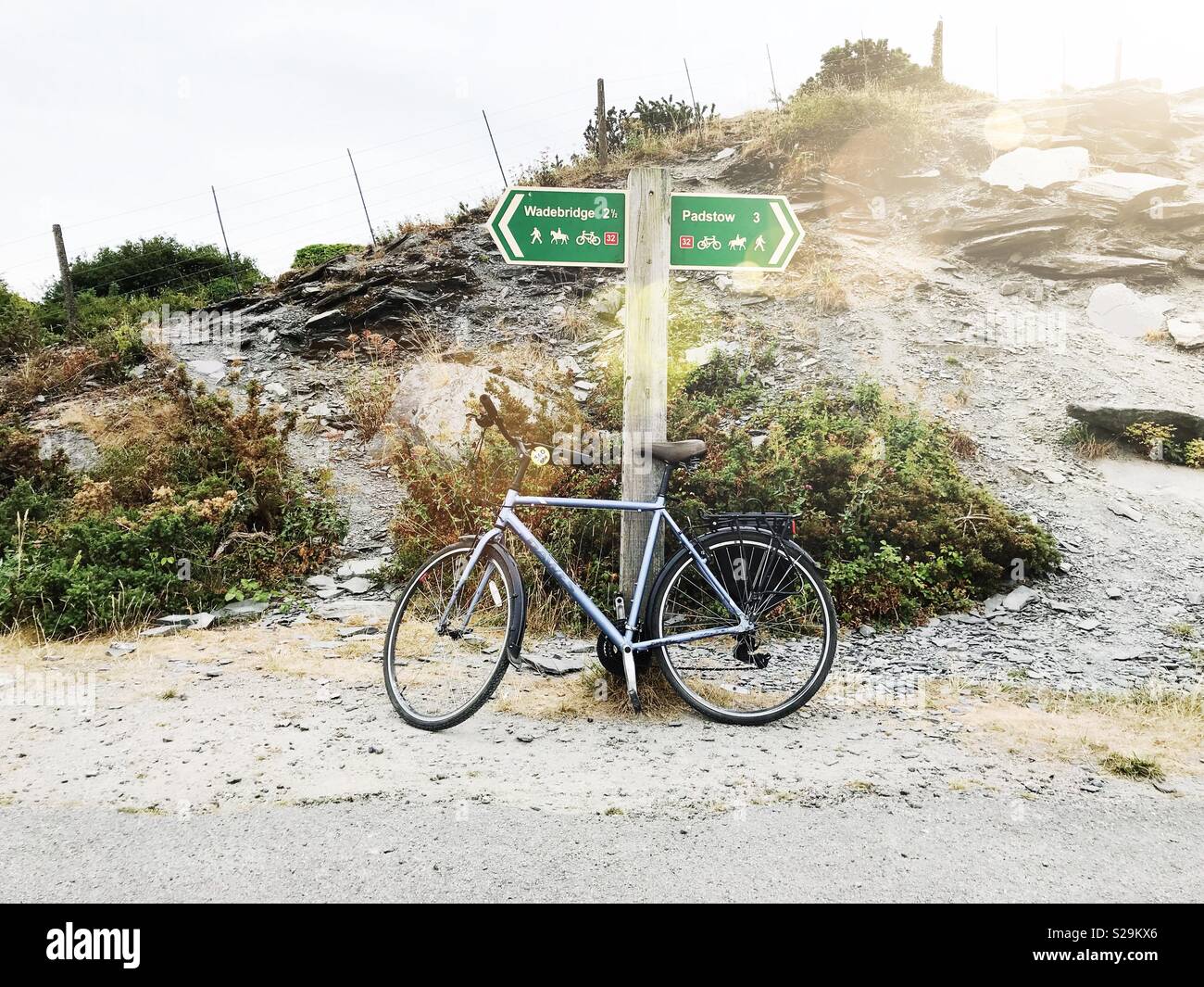 A bicycle leaning against a road sign along the Camel Trail cycleway in