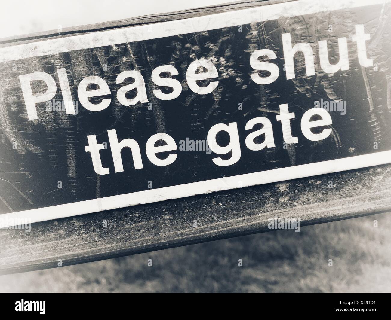 Please shut the gate sign in mono Stock Photo