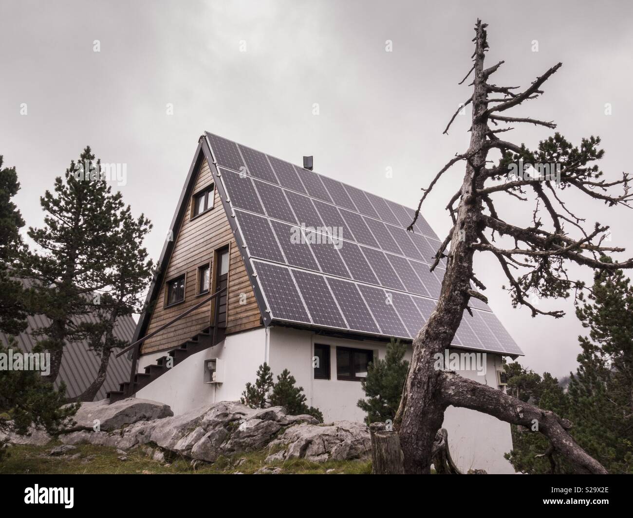 Chalet with solar panels on the roof in the french Pyrenees. Stock Photo