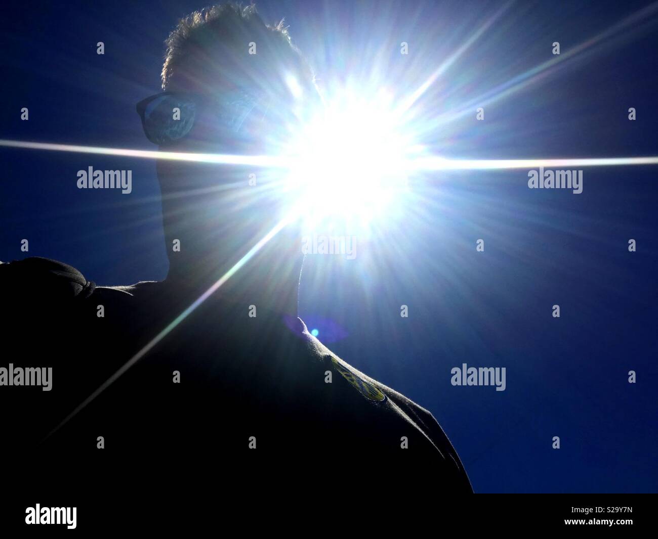 Man looking with sun behind and blue sky - Smartphone Captured Stock Image