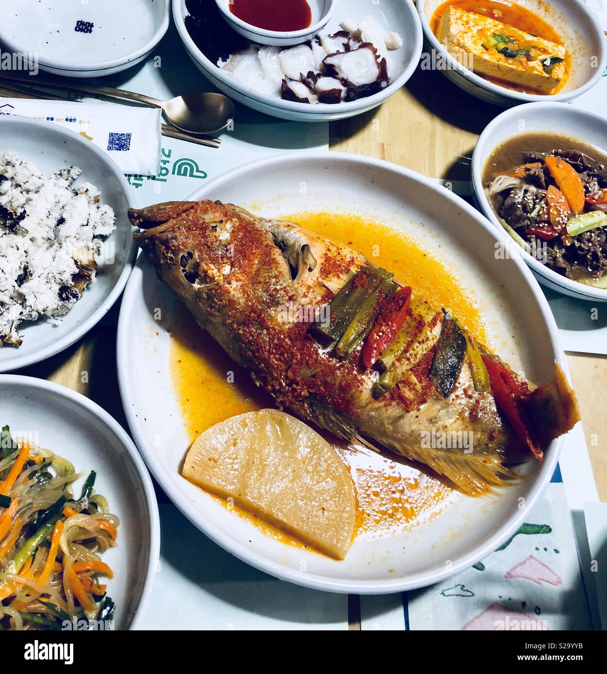 Main fish dish served along with all these tasty side dishes at a feast in Gangneung, South Korea. - Smartphone Captured Stock Image