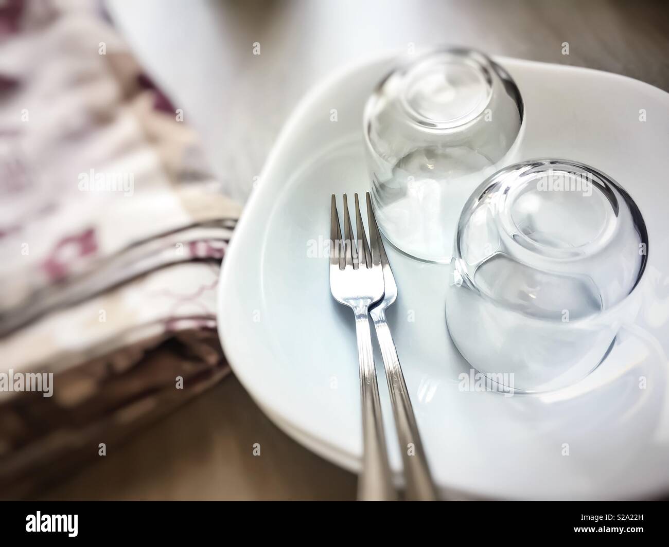 Setting the table with forks, white plates, glasses and tablecloth - Smartphone Captured Stock Image