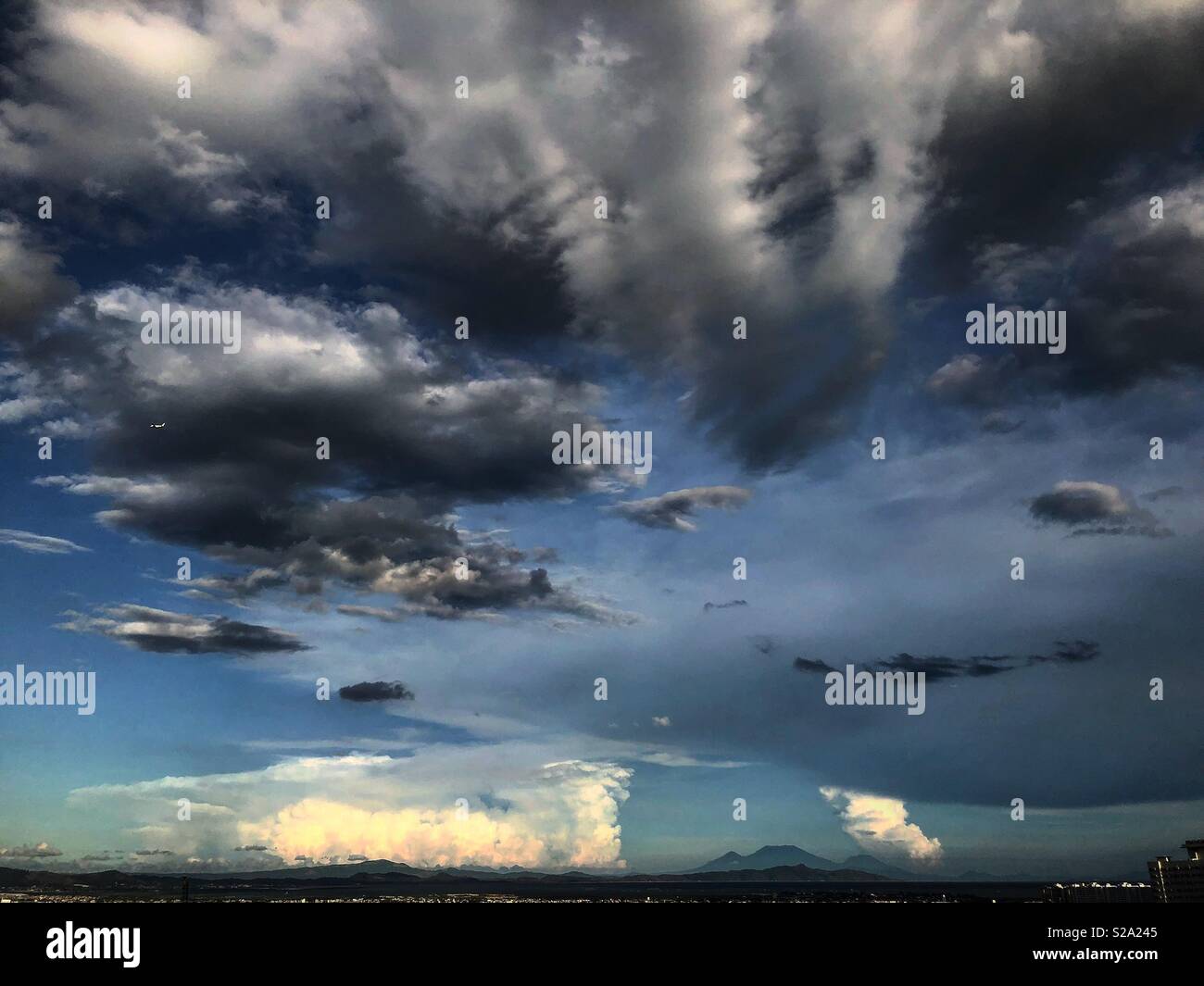 Anomalistic patterns of the clouds in abstract forms. NOT PHOTOSHOPPED. Taken from a balcony in a city within the Philippines, with Mountains in the horizon, around the afternoon. Stock Photo