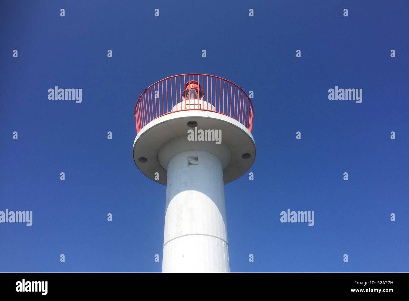 The top of a lighthouse with a clear blue sky as background. - Smartphone Captured Stock Image