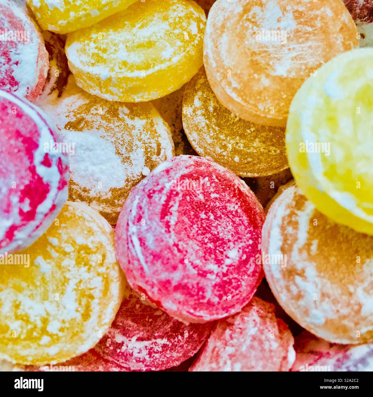 Bright, icing sugar-covered hard boiled  travel sweets .  Candies with confectioners sugar Stock Photo