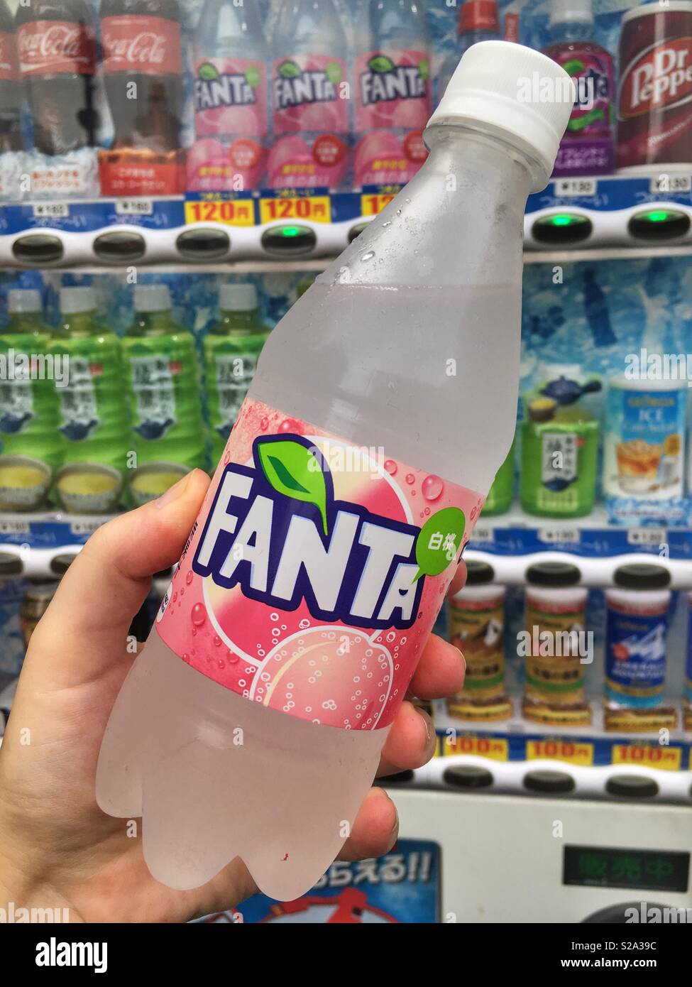 Japanese White Peach Fanta held in front of a vending machine Stock Photo