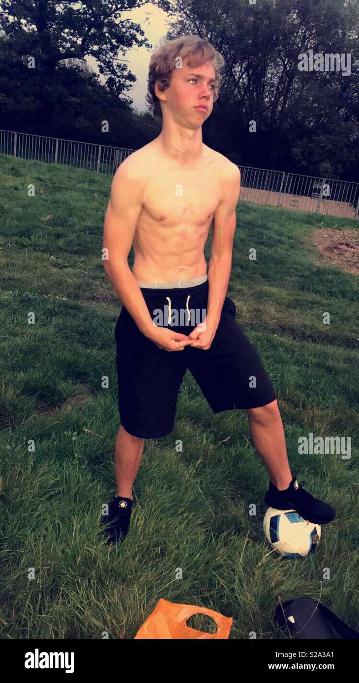 A boy playing football and showing off his muscles Stock Photo Alamy