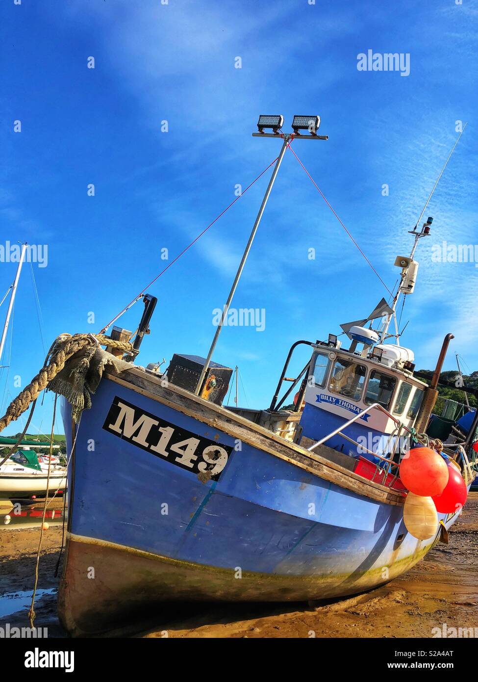 Fishing boat in the harbour at New Quay, West Wales, low tide. Stock Photo