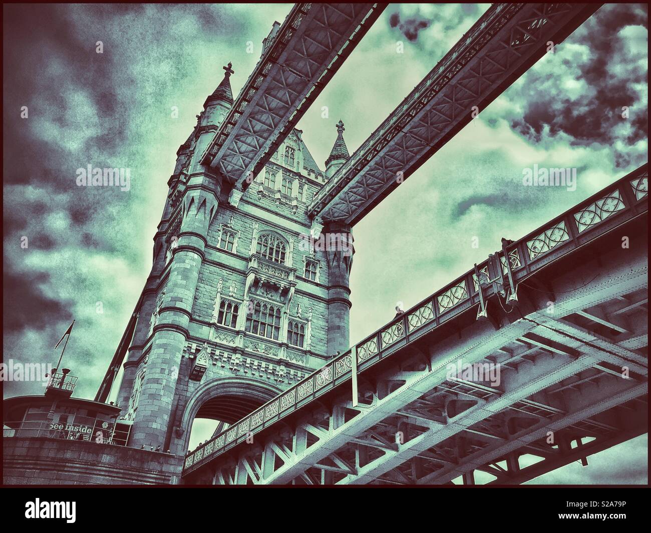 An unusual view of Tower Bridge in London, England. This iconic Victorian structure is a must see for any visitor to London. A view looking up from the River Thames. Photo Credit -© COLIN HOSKINS. Stock Photo