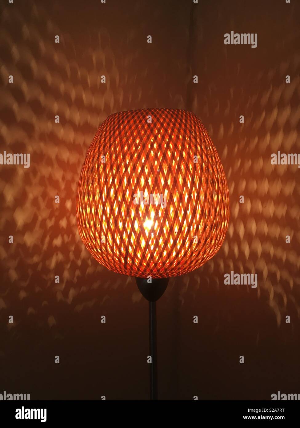 Wicker lamp casting a warm and interesting light play and shadow ...