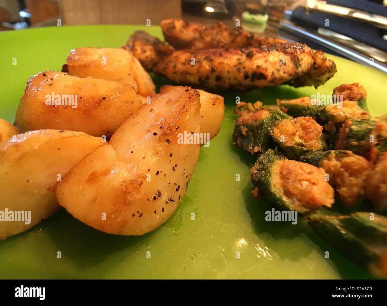 Dinner is grilled chicken, fried okra, and potatoes Stock Photo Alamy