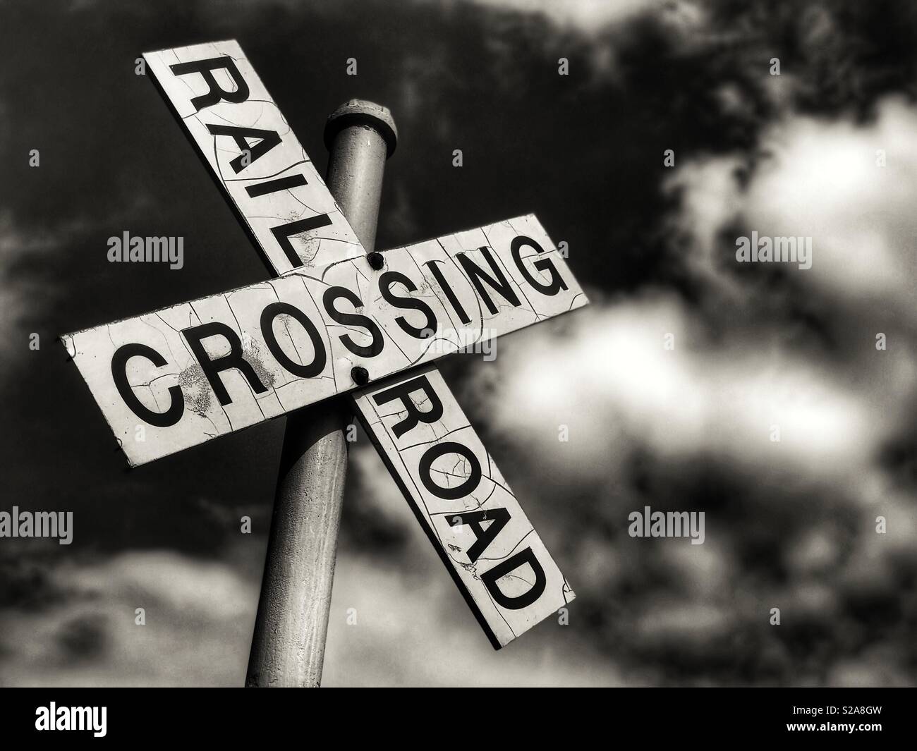 Railroad crossing sign with puffy clouds in the background - Smartphone Captured Stock Image