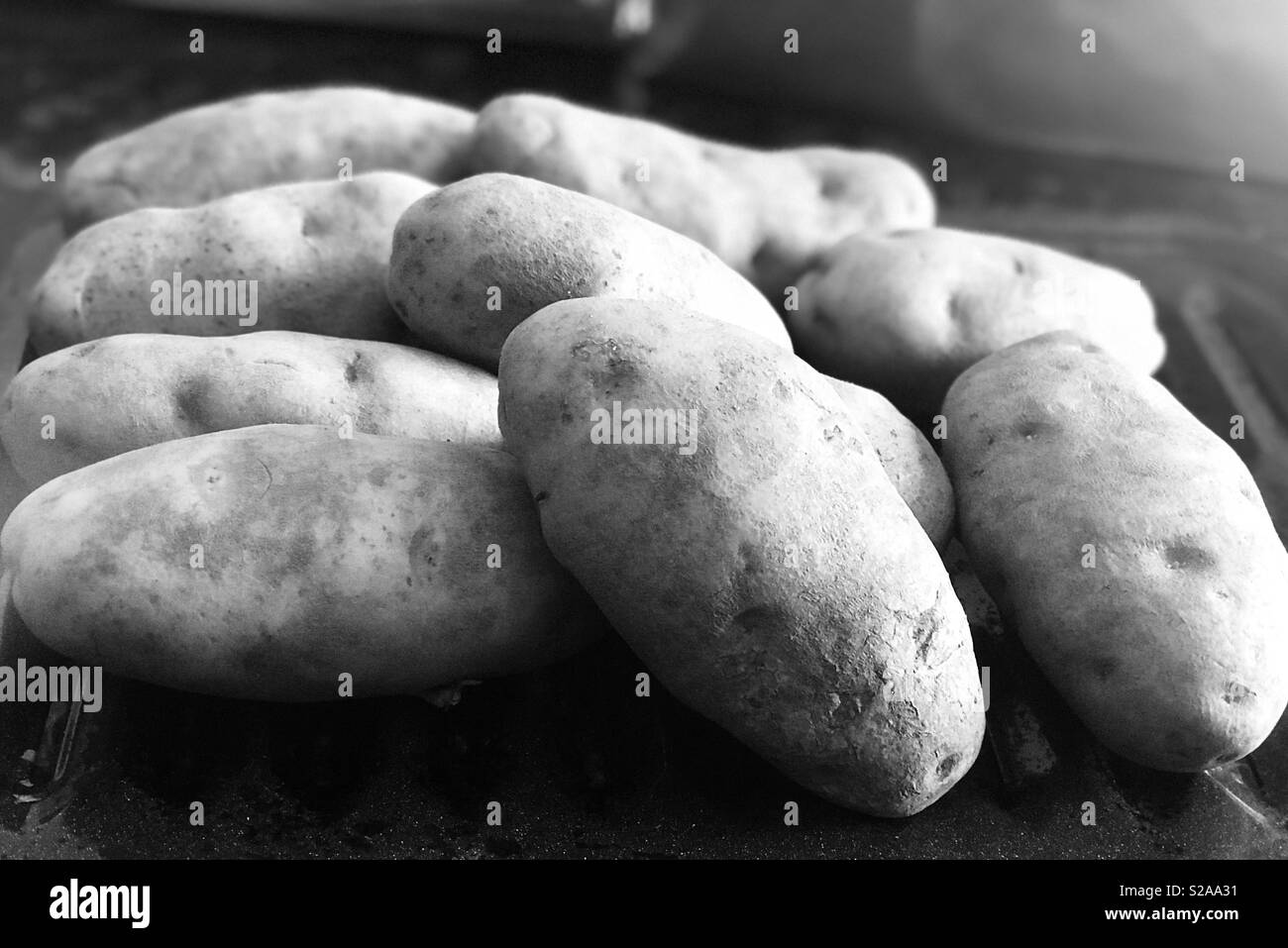 Rustic golden potatoes in a black sand white photograph Stock Photo