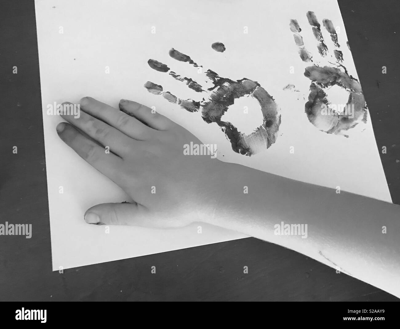 Black and white photo of child’s hand prints using finger paints Stock Photo