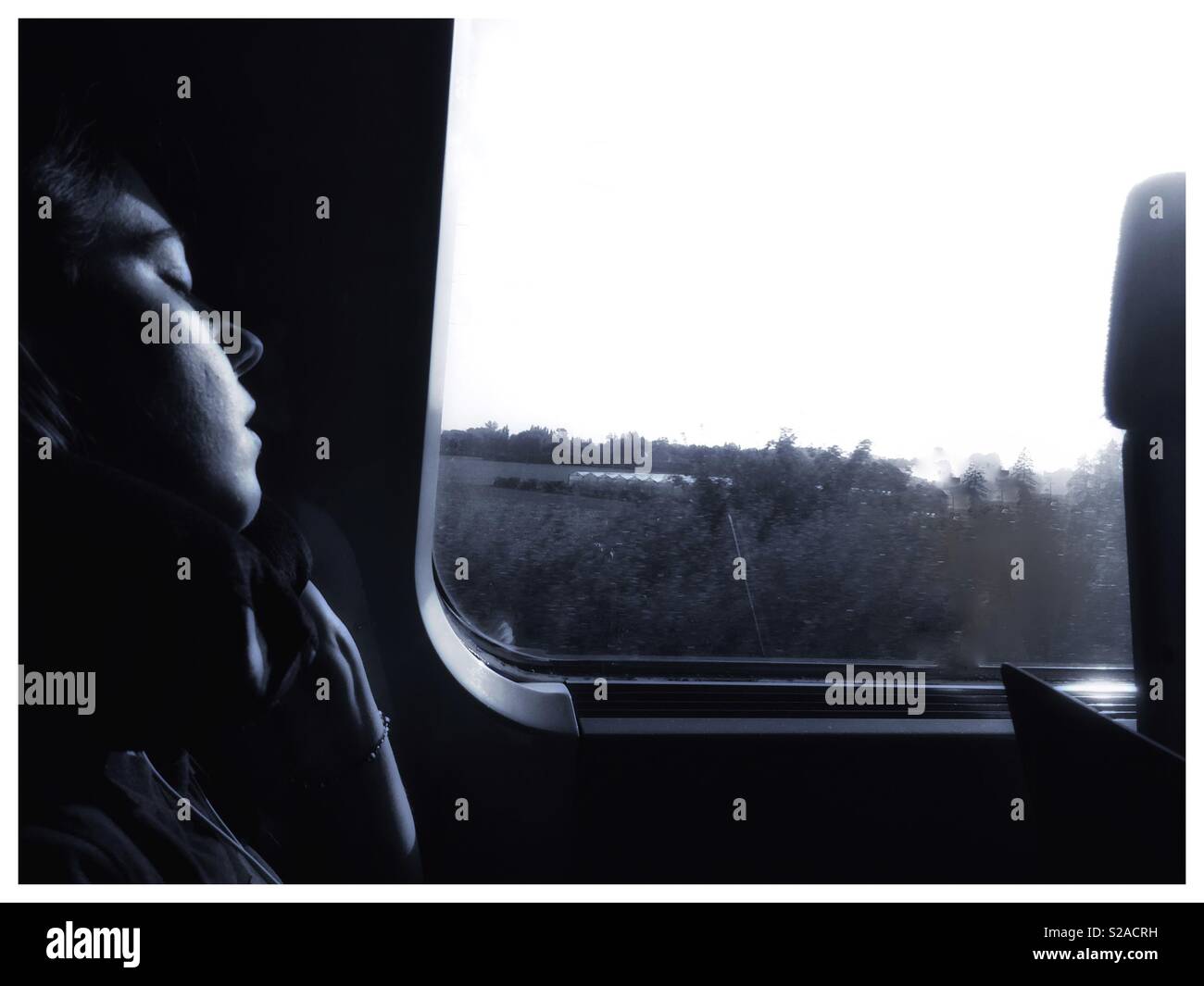 A woman asleep on a train. - Smartphone Captured Stock Image