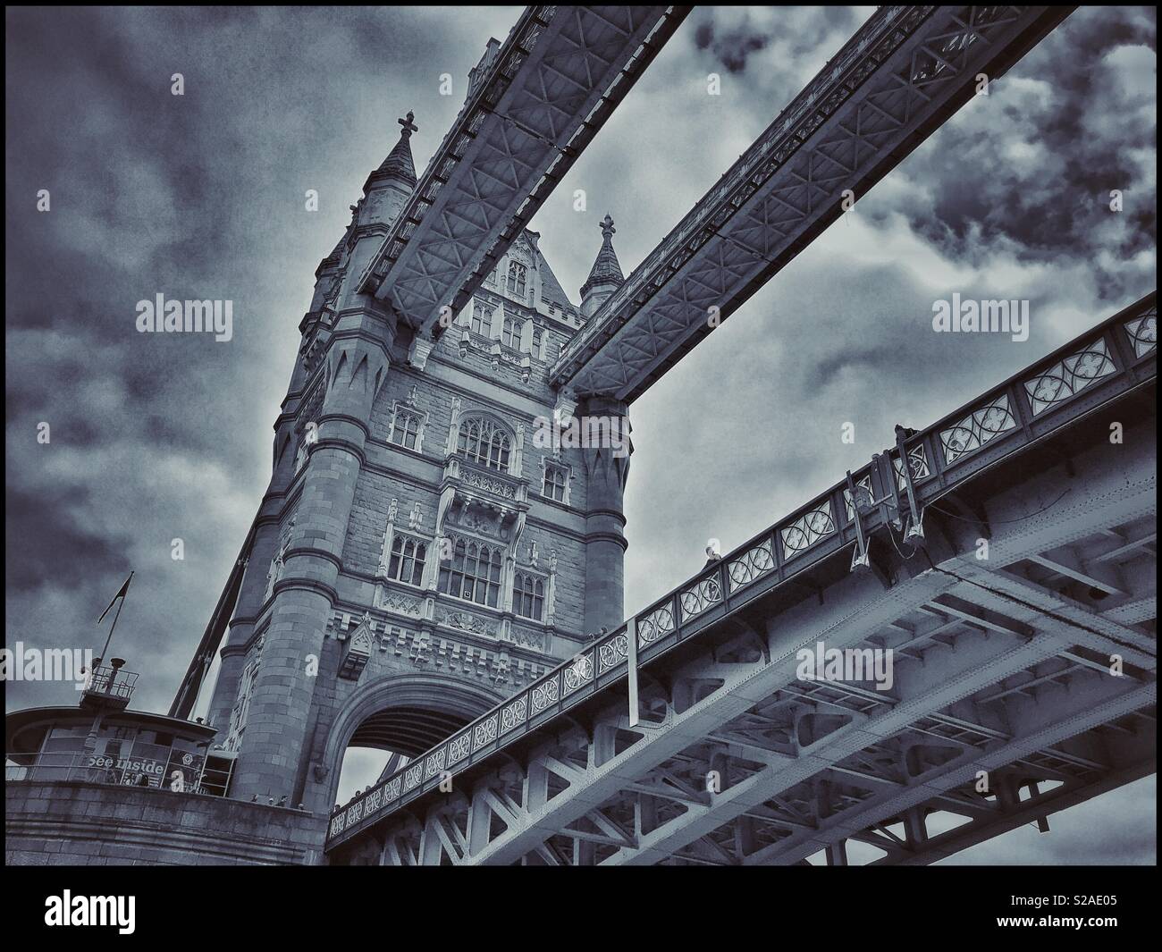 An unusual view of Tower Bridge - a view looking up from a boat on the River Thames. Tower Bridge is a Grade 1 Listed Building and a Tourist must see in London, England. Photo Credit © COLIN HOSKINS. Stock Photo