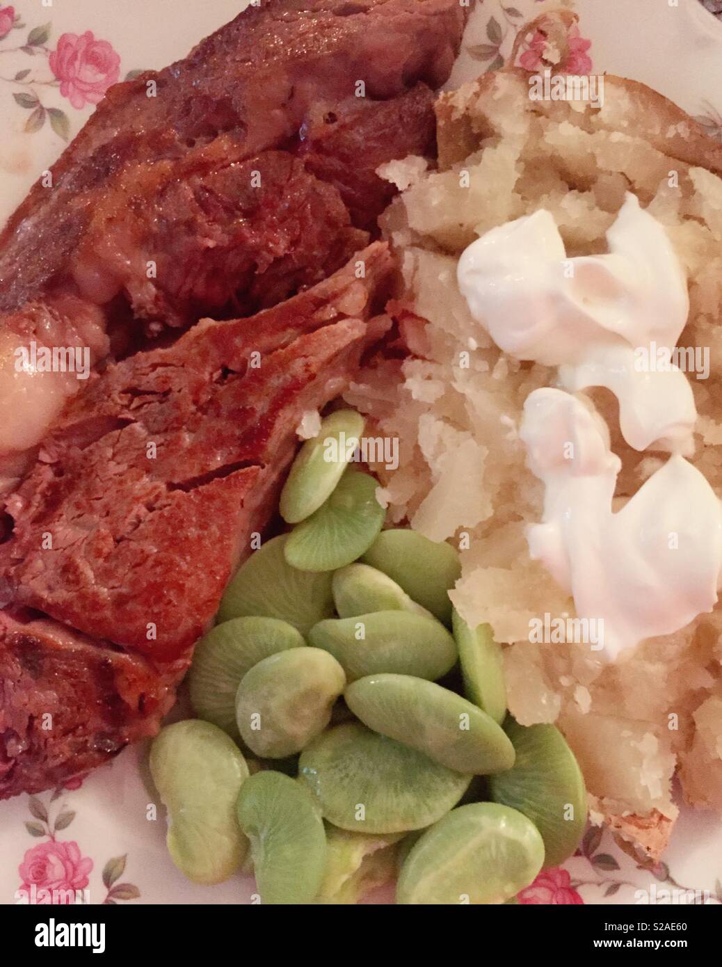 Hearty balanced meal grilled steak, baked potato and fresh lima beans, USAA - Smartphone Captured Stock Image