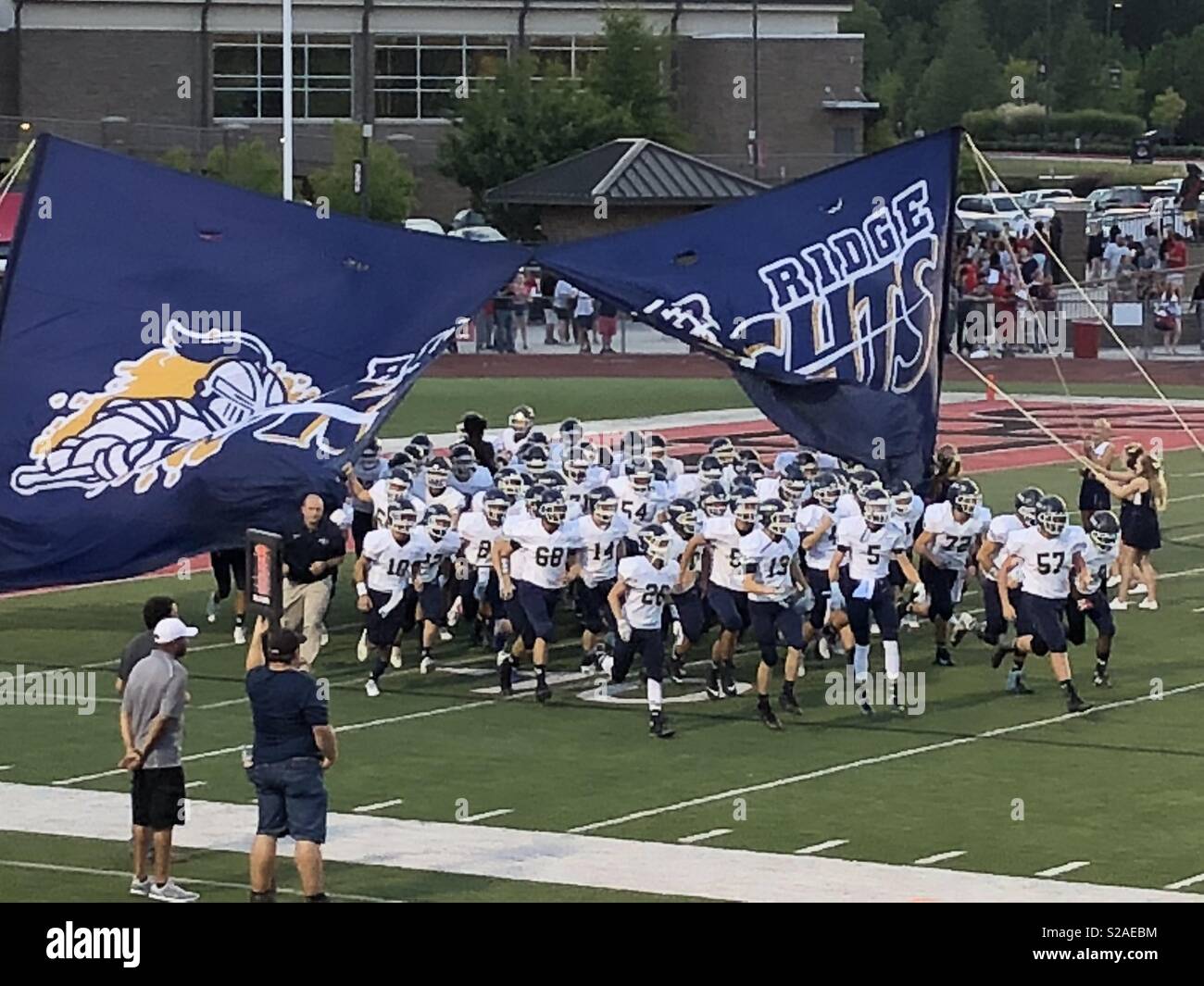 River Ridge High School football team running on to the football field before the game. Stock Photo