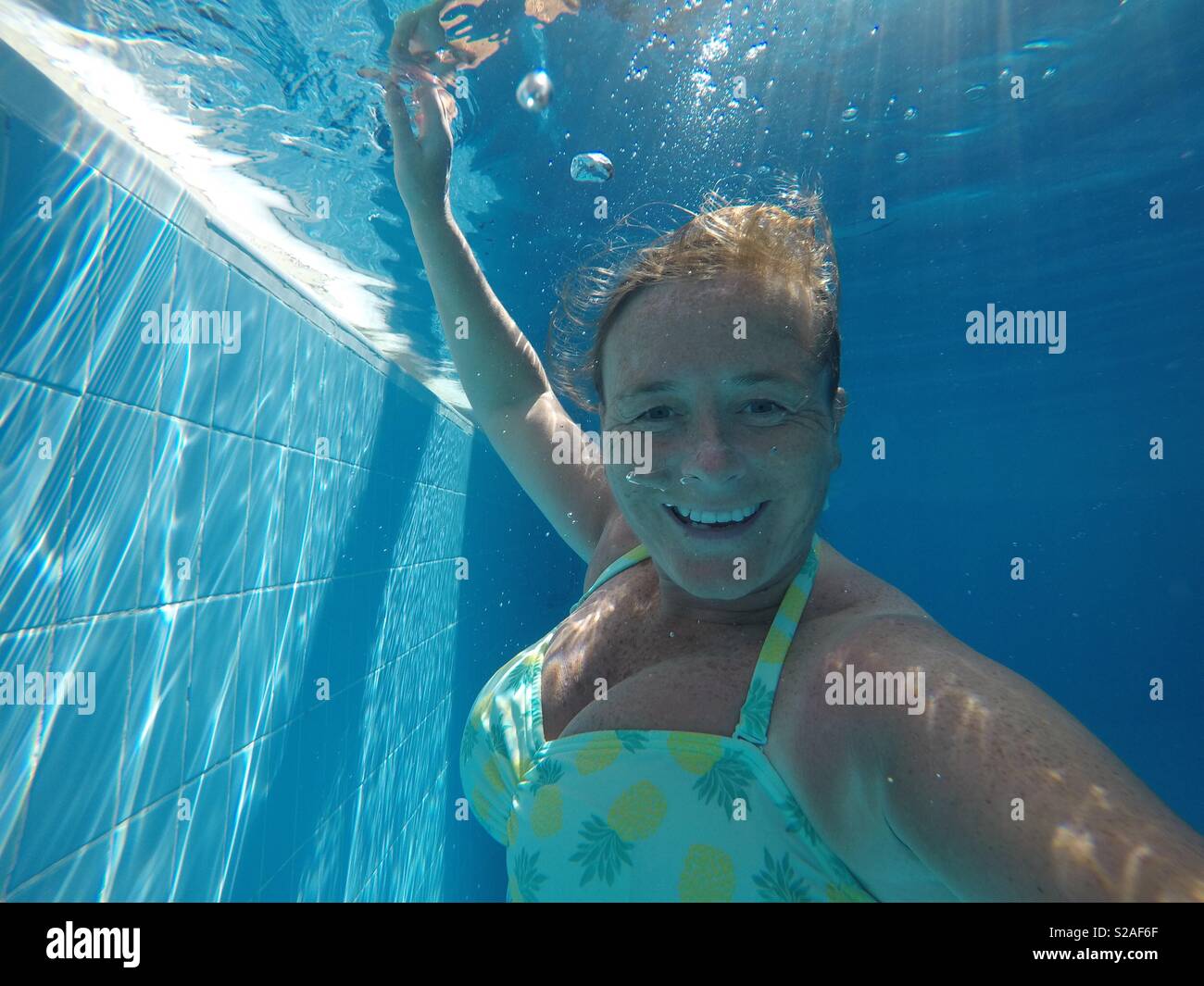 A lady smiling underwater with her eyes open Stock Photo Alamy